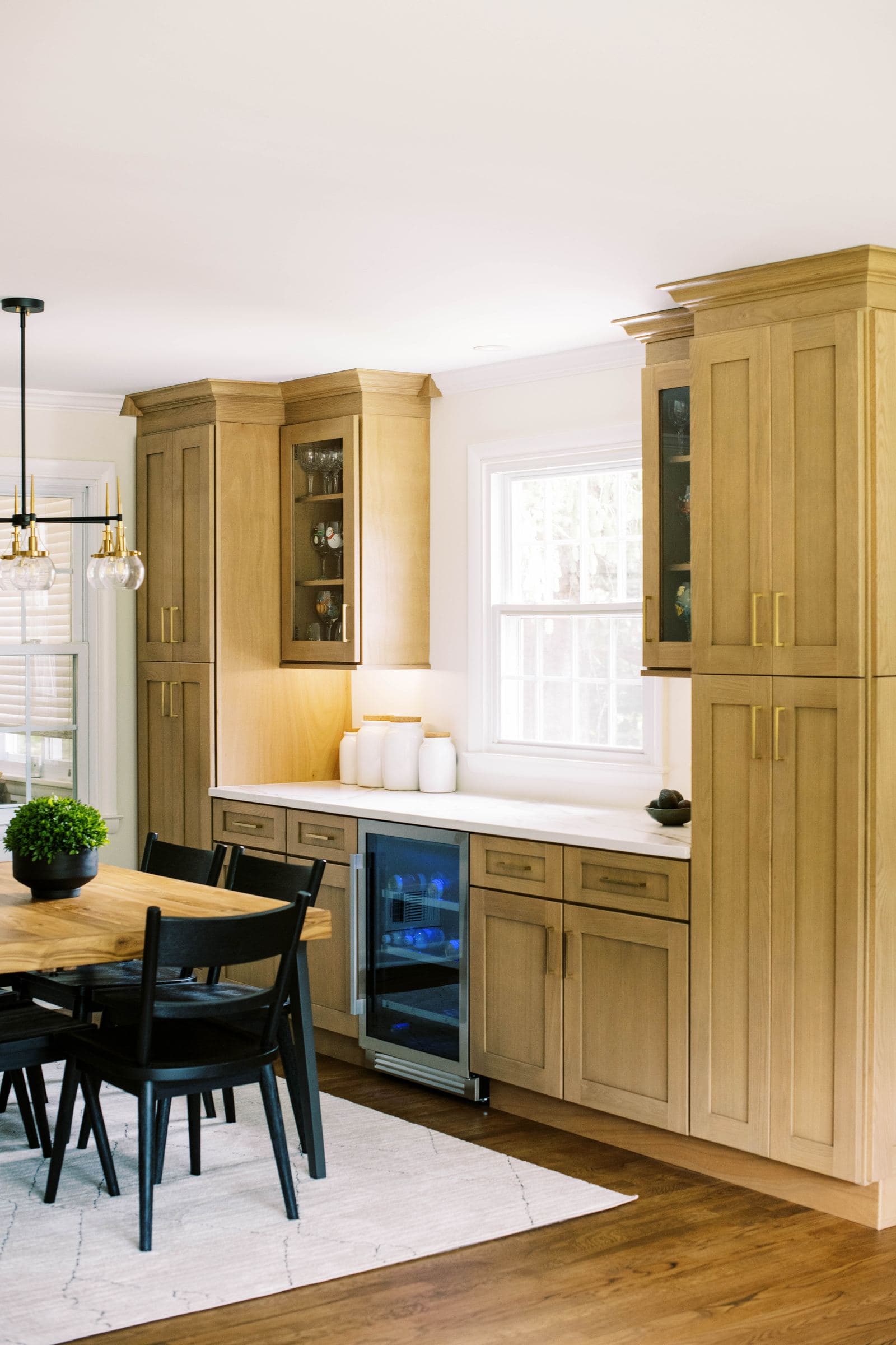 White oak dining room hutch with glass-front cabinets and a beverage cooler